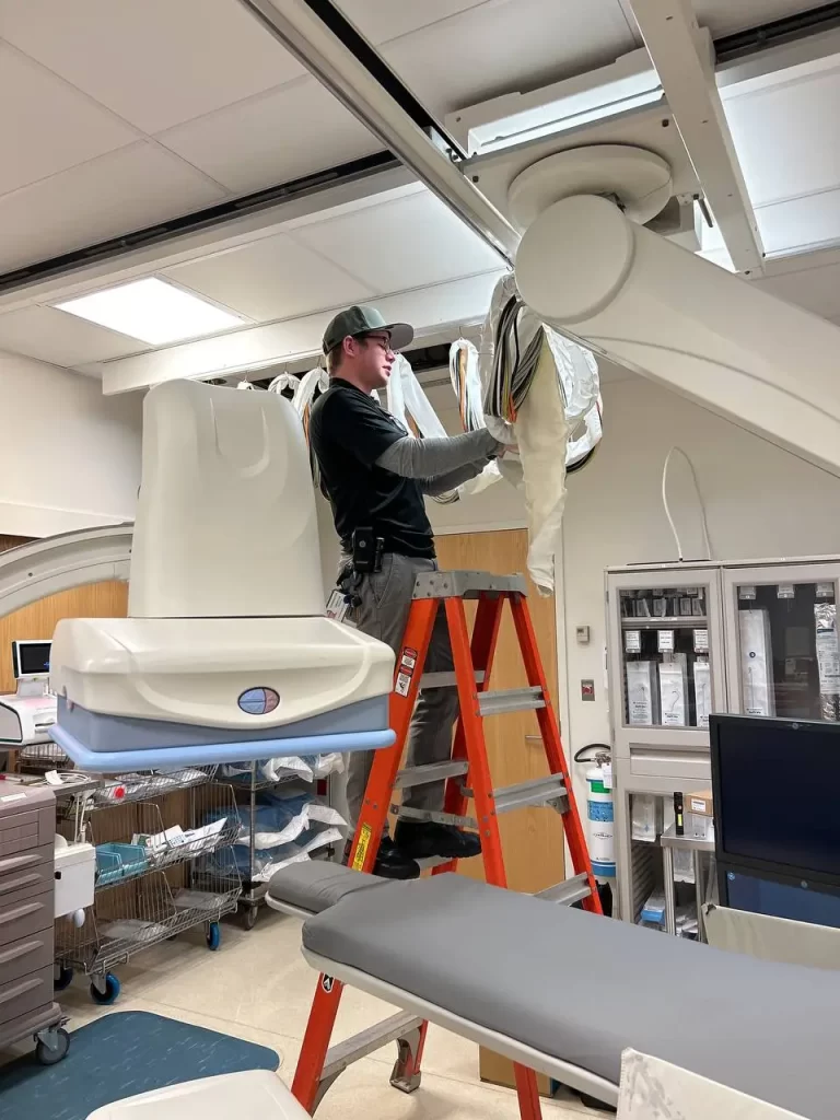 Precision Networks team member servicing medical imaging equipment in a hospital